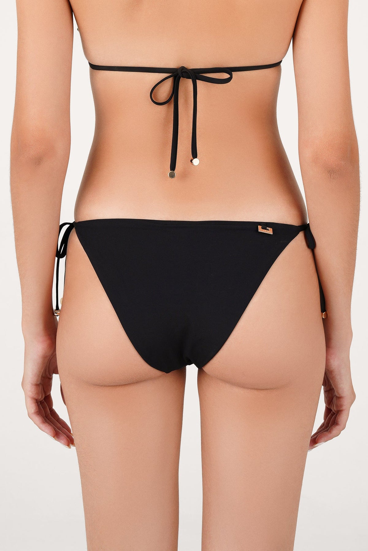 Calzón de bikini negro visto de espalda con amarres laterales y detalles de tachuelas en la cintura