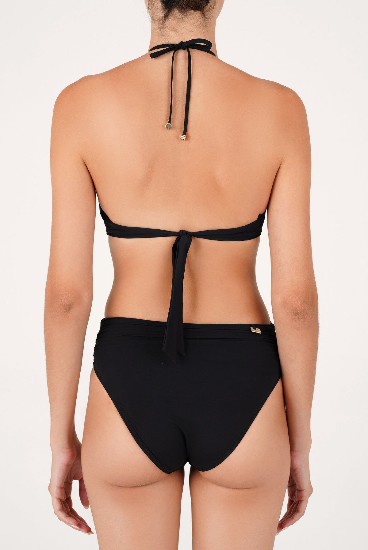 Traje de baño completo negro visto de espalda, con amarre halter al cuello y espalda descubierta