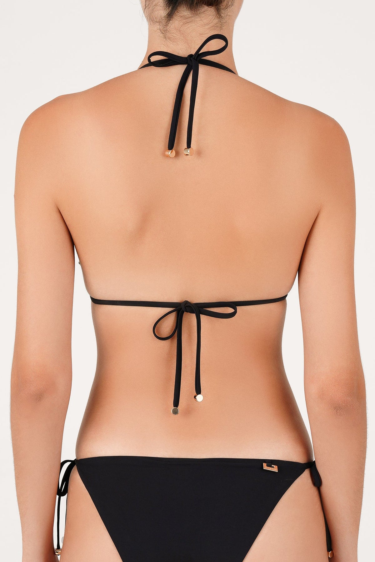 Top de bikini negro visto de espalda: con amarres en el cuello y la cintura con detalles metálicos en las puntas